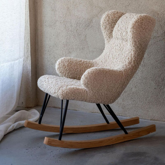 Rustic rocking chair with wooden base against a textured wall.