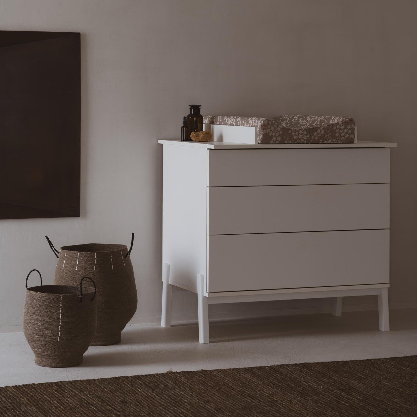 White dresser with decorative items against a plain wall