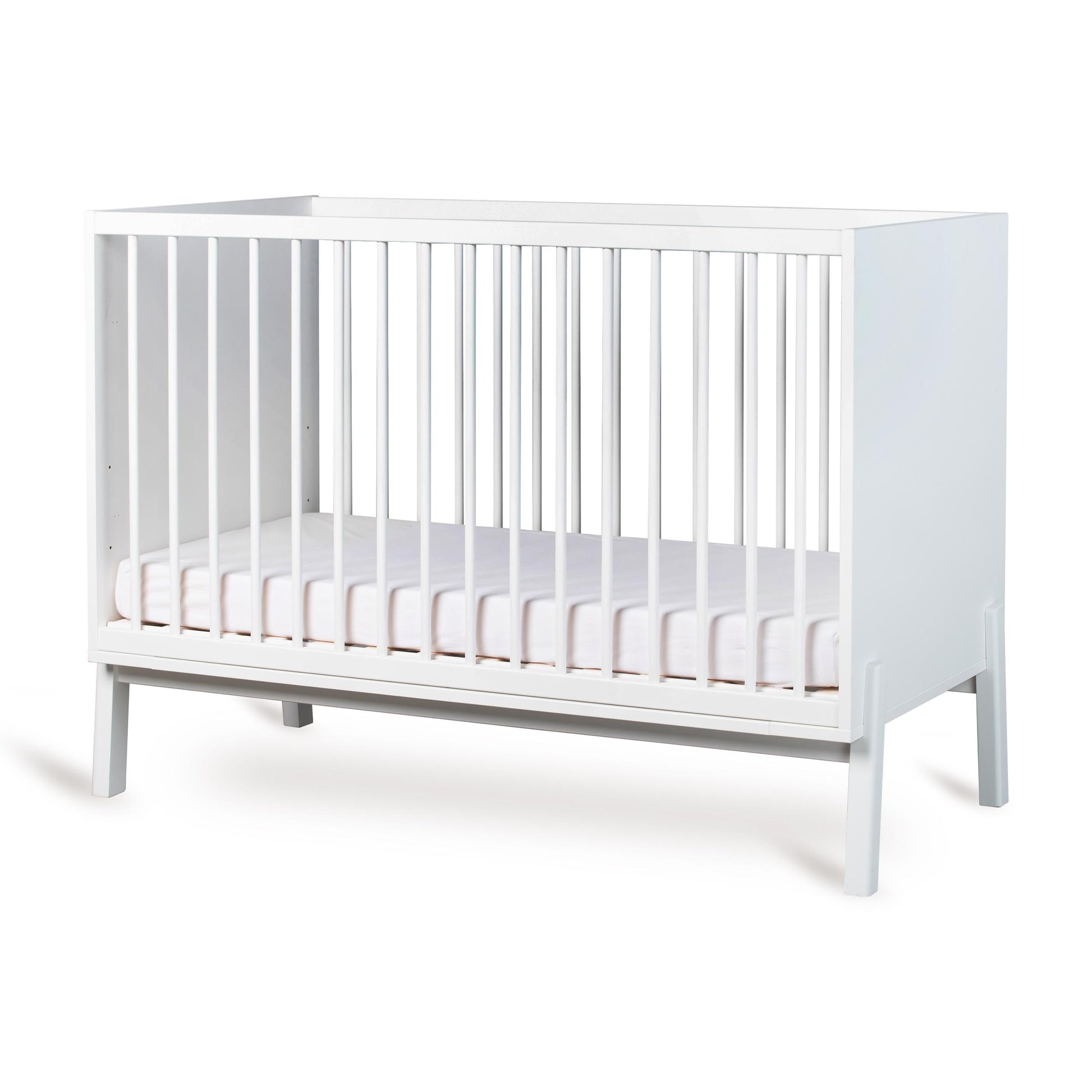Cream crib with a white mattress on a white background