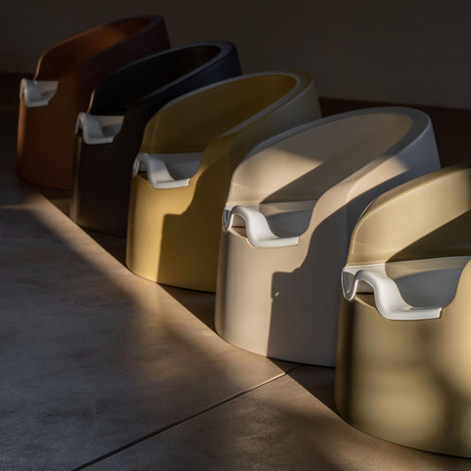 Row of modern stools with different colors on a dark floor.