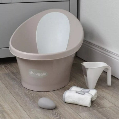 Baby bath seat with accessories on a wooden floor