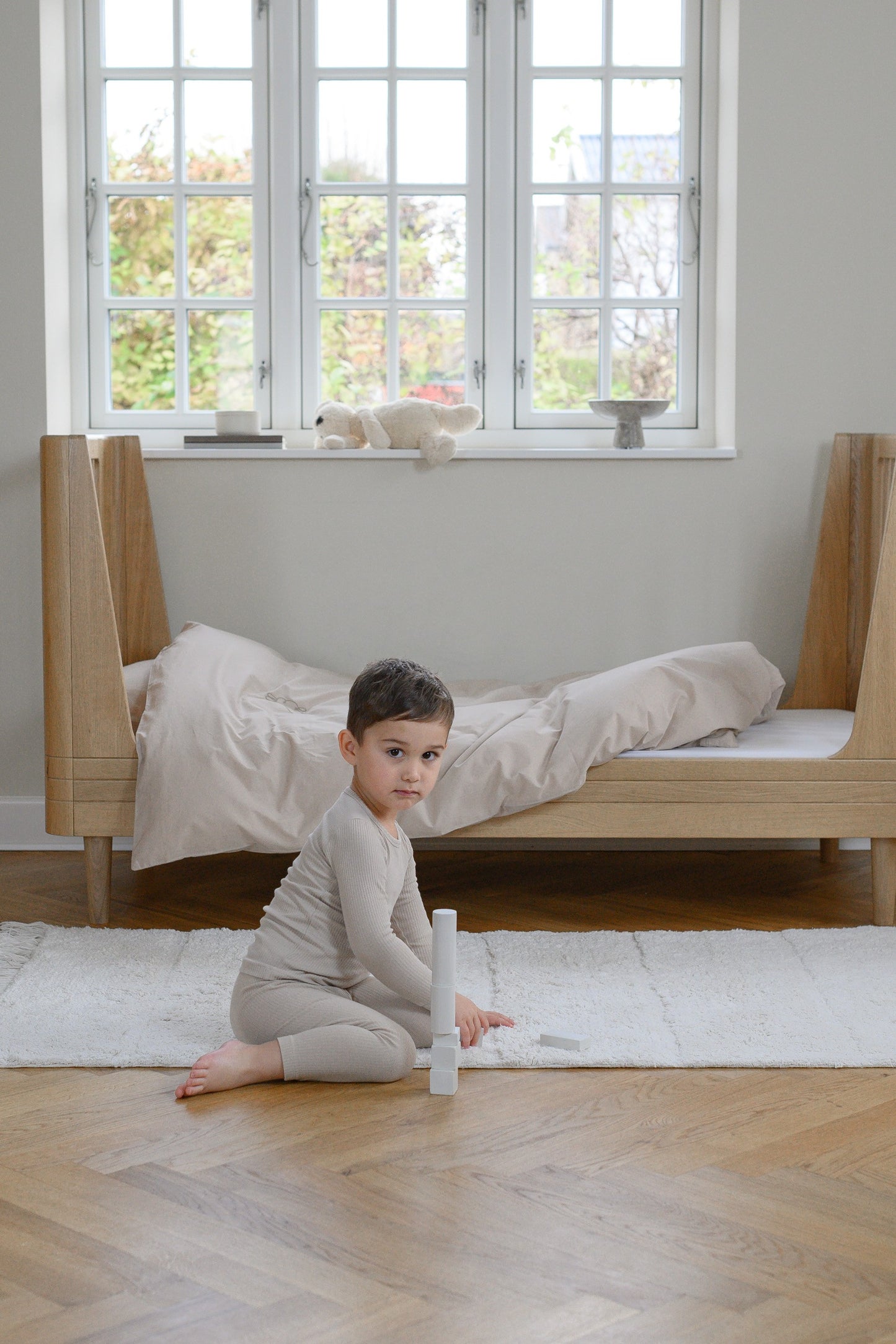 We are Bitte Toddle bed in Oak, with boy playing on the floor- by MK Kids Lifestyle-UK