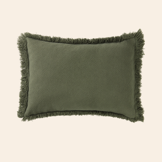 Green pillow with frayed edges on a beige background