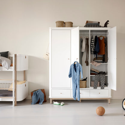 Children's room with a white wardrobe, toys, and a balance bike.